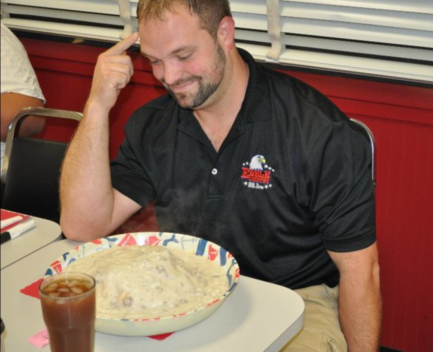 A Howie's Biscuit & Gravy Challenge attempter, daunted by the gallon of gravy and 16 biscuits before him.