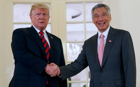 President Donald Trump shakes hands as he meets with Singapore Prime Minister Lee Hsien Loong ahead of a summit with North Korean leader Kim Jong-un - Credit: AP