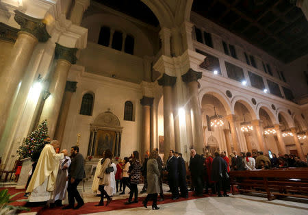 FILE PHOTO: Egyptian Catholics stand in line to receive Holy Communion during a mass on Christmas eve at Saint Joseph's Roman Catholic Church in the capital of Cairo, Egypt December 24, 2017. REUTERS/Amr Abdallah Dalsh/File Photo