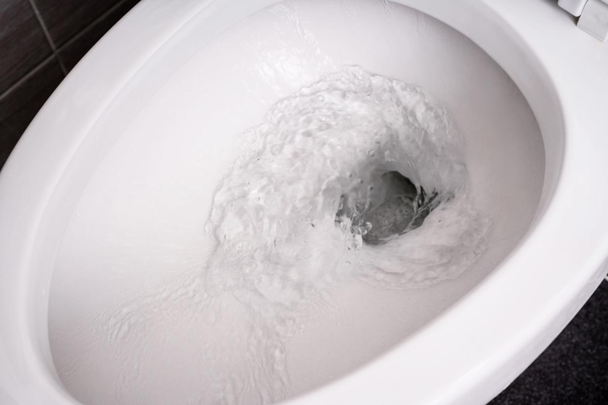 close up flushing water in toilet bowl