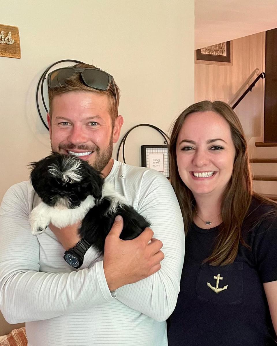 Cory Miller holds a puppy in his hands