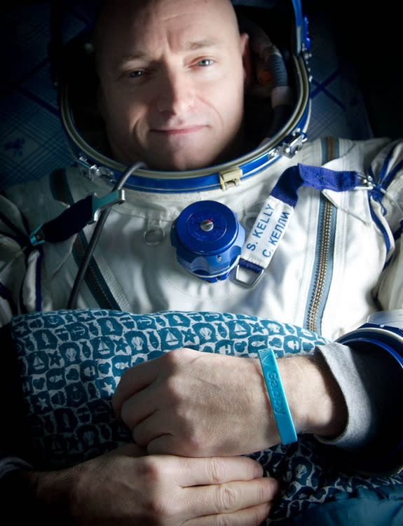 Expedition 26 Commander Scott Kelly wears a blue wrist band that has a peace symbol, a heart and the word "Gabby" to show his love of his sister-in-law U.S. Rep. Gabrielle Giffords as he rests shortly after he and cosmonauts Oleg Skripochka and