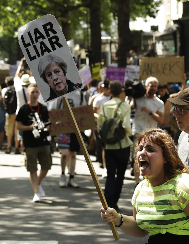 A protestor holds a placard at the #DayofRage protest (Picture: REX Features)