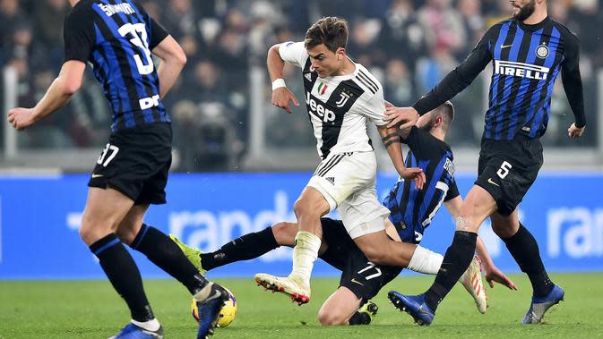 Striker Juventus, Paulo Dybala, berusaha melewati pemain Inter Milan pada laga Serie A di Stadion Allianz, Turin, Jumat (7/12). Juventus menang 1-0 atas Inter Milan. (AP/Andrea Di Marco)