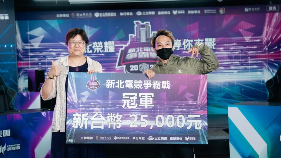 經發局長何怡明 (左)與《聯盟戰棋》冠軍爆豪1合影，獲得2萬5千元獎金。   圖：新北市經發局提供