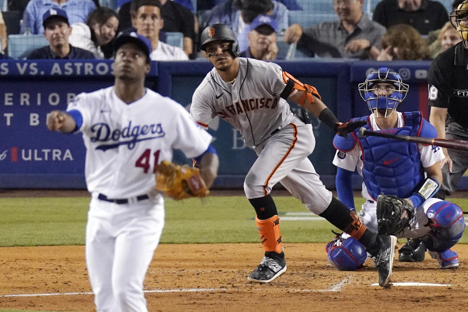 San Francisco Giants' Thairo Estrada, center, runs to first after hitting a solo home run as Los Angeles Dodgers relief pitcher Josiah Gray, left, watches along with catcher Austin Barnes during the fifth inning of a baseball game Tuesday, July 20, 2021, in Los Angeles. (AP Photo/Mark J. Terrill)