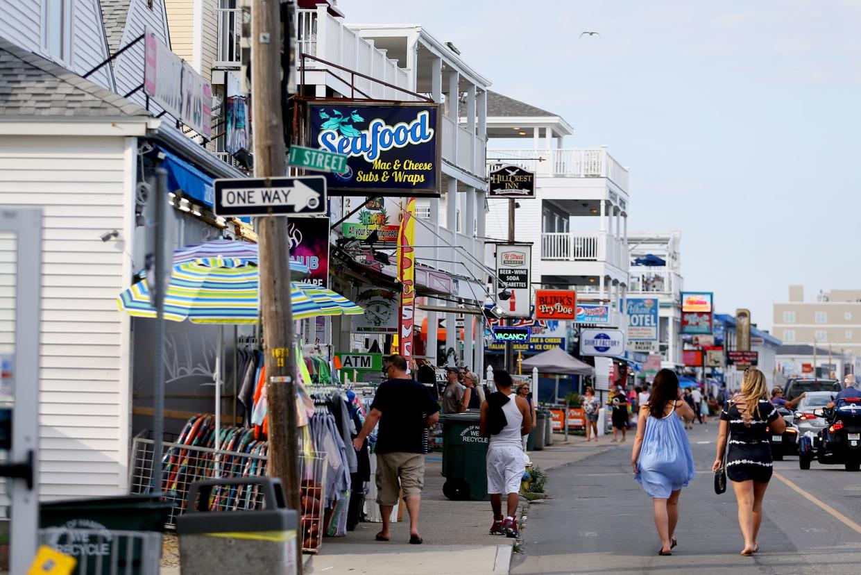 Visitors walk along the boardwalk in Hampton Beach on Wednesday afternoon.