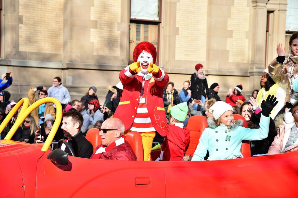 Ronald McDonald waved from his car ahead of his float in a McDonald's mobile.