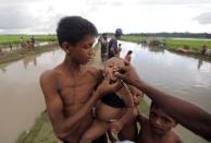 A Rohingya refugee boy who crossed the border from Myanmar a day before, gets an oral cholera vaccine, distributed by UNICEF workers as he waits to receive permission from the Bangladeshi army to continue his way to the refugee camps, in Palang Khali, near Cox's Bazar, Bangladesh October 17, 2017. REUTERS/ Zohra Bensemra