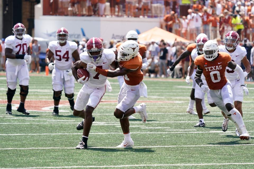 Alabama wide receiver Ja'Corey Brooks (7) tackled fights off Texas defender Anthony Cook during their team's 2022 game at Darrell K Royal-Texas Memorial Stadium.