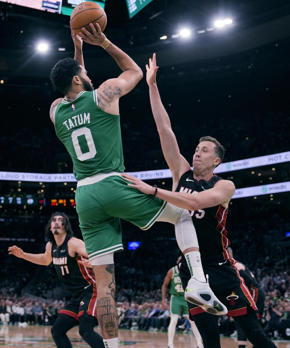 Boston Celtics forward Jayson Tatum (0) takes a shot over Miami Heat forward Duncan Robinson, right,during the first half of Game 2 of an NBA basketball first-round playoff series, Wednesday, April 24, 2024, in Boston. (AP Photo/Charles Krupa)