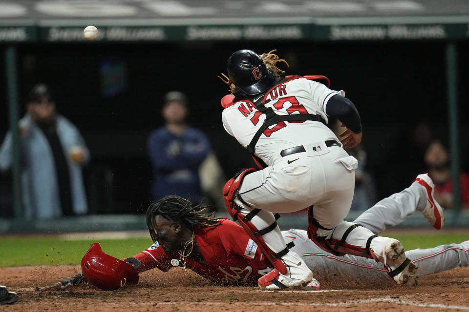 Cincinnati Reds' Elly De La Cruz, left, scores as Cleveland Guardians catcher Bo Naylor (23) reaches for the ball during the fifth inning of a baseball game Tuesday, Sept. 26, 2023, in Cleveland. (AP Photo/Sue Ogrocki)