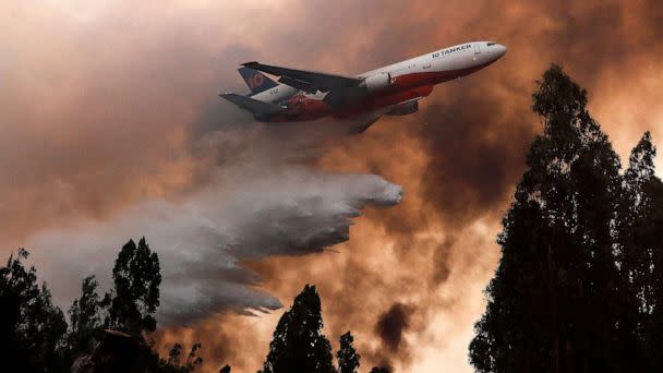 PHOTO: A 10 Tanker DC-10 fire plane throws water over a forest fire in Ninhue, Ã‘uble Region, in Chile, on February 10, 2023. - Forest fires have raged for more than a week in south-central Chile, leaving at least 24 people dead. (Javier Torres/AFP via Getty Images)