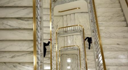 Two men hold onto the bannister as they ascend a staircase in the Rayburn House Office Building on Capitol Hill in Washington April 24, 2013. REUTERS/Kevin Lamarque