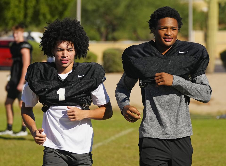Hamilton wideouts Legend Bernard (L) and Tre' Spivey warm up during a practice at Hamilton High School in Chandler on Oct. 18, 2022.