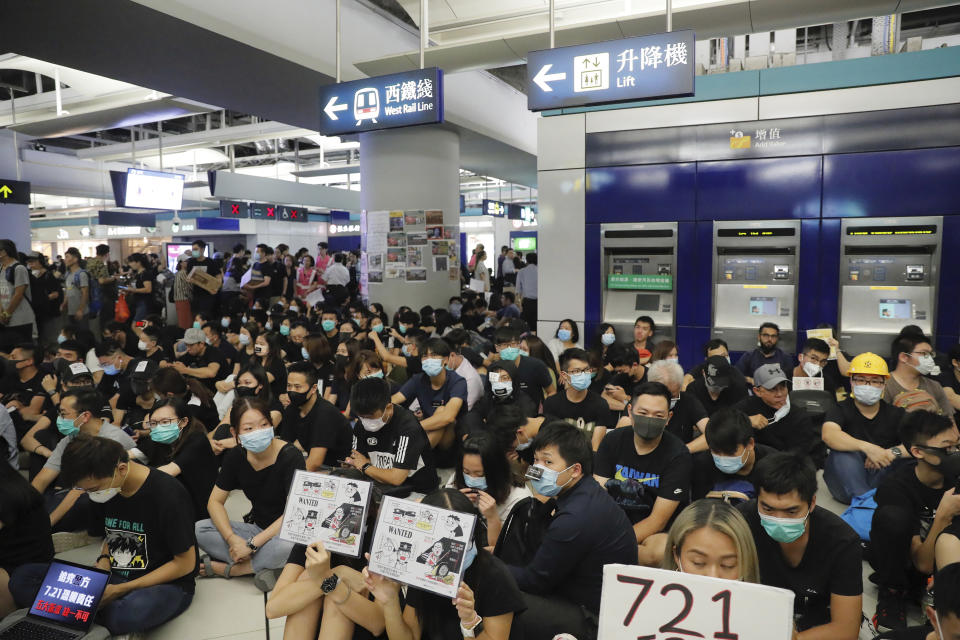 Demonstrators sit during a protest at the Yuen Long MTR station, where demonstrators and others were violently attacked by men in white T-shirts following an earlier protest in July, in Hong Kong, Wednesday, Aug. 21, 2019. Hundreds of Hong Kong protesters held a sit-in at a suburban train station to mark the anniversary of a violent attack there by masked assailants on supporters of the antigovernment movement. (AP Photo/Kin Cheung)