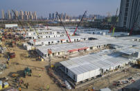 FILE - In this Feb. 4, 2020, file photo released by China's Xinhua News Agency, construction workers labor at the Leishenshan Hospital, the second temporary field hospital being built in Wuhan in central China's Hubei Province. The virus outbreak that began in China and has spread to more than 20 countries is stretching already-strained public health systems in Asia and beyond, raising questions over whether everyone can get equal access to treatment. (Xiao Yijiu/Xinhua via AP)