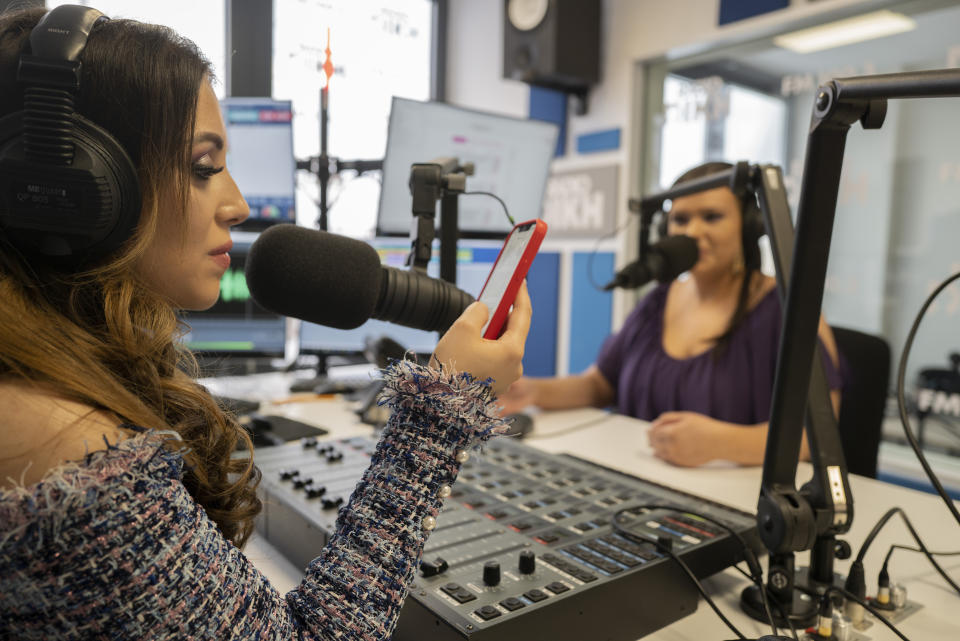 Melanie Nagy, left, and Szandi Minzari, hosts of Radio Dikh's women's show 'Zsa Shej', work together in a radio studio in Budapest, Hungary, Friday May 6, 2022. Intellectuals, broadcasters and cultural figures from Hungary’s Roma community have founded a radio station to reframe narratives and elevate the voices of their marginalized minority group. (AP Photo/Bela Szandelszky)