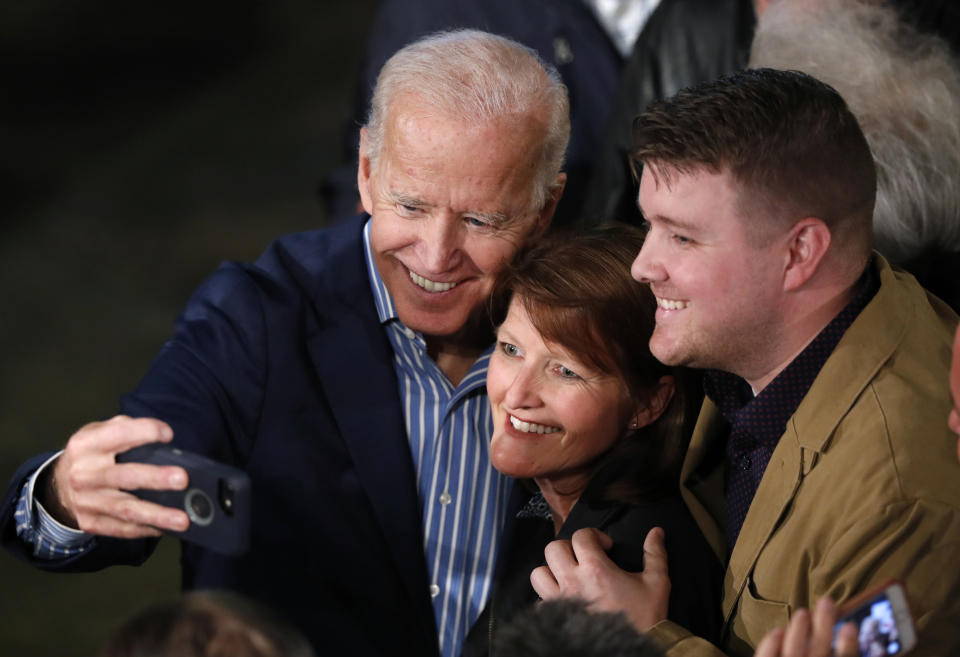 Joe Biden se saca un selfie con dos partidarios durante un acto en Des Moines, Iowa, el 1ro de mayo del 2019. (AP Photo/Charlie Neibergall)