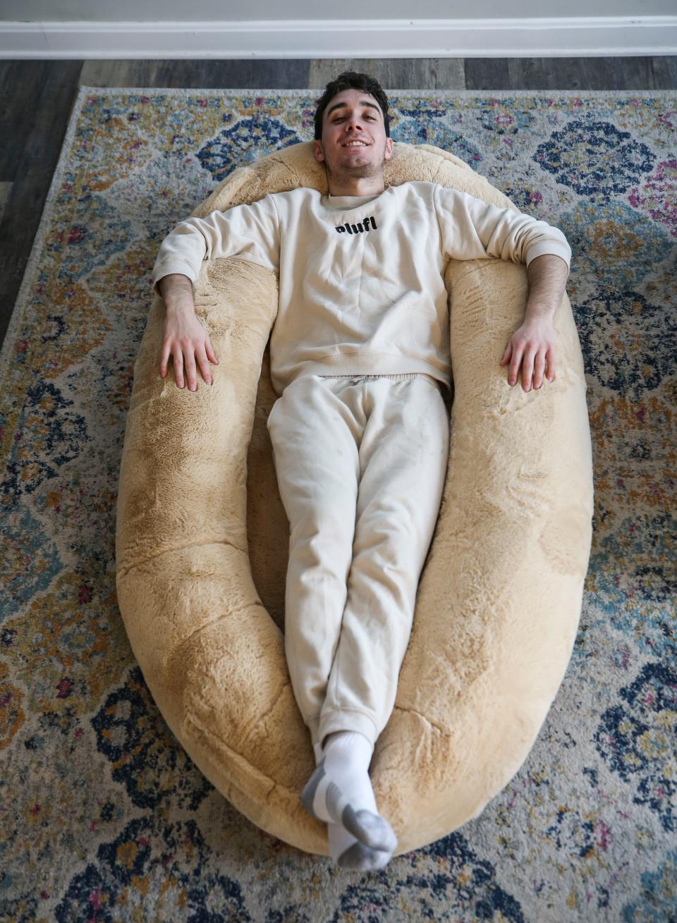 Noah Silverman, one of the founders of Plufl, shows how the human-sized dog bed can be used.  December 2022