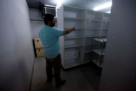 A man points to empty medicine shelves in a store at Tripoli Medical Center in Tripoli, Libya, July 20, 2016. Picture taken July 20, 2016. REUTERS/Ismail Zitouny