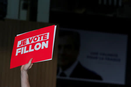 A supporter of the French centre-right presidential candidate Francois Fillon holds a placard reading 'I vote for Fillon', at a political rally in Paris, France, April 9, 2017. REUTERS/Benoit Tessier A suppo