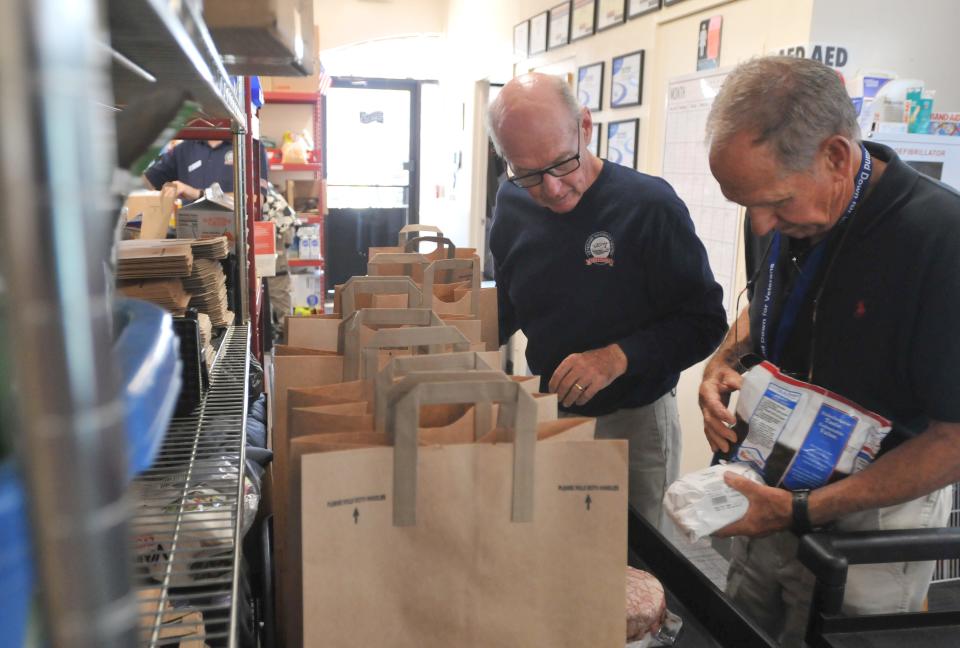 Harwich resident and volunteer Wilfred Remillard, a retired Harwich fire chief and retired town veterans service agent, left, and volunteer Bob Clay, of Osterville, bag groceries on Sept. 7 for a client of the food pantry of the Cape and Islands Veterans Outreach Center in Hyannis.