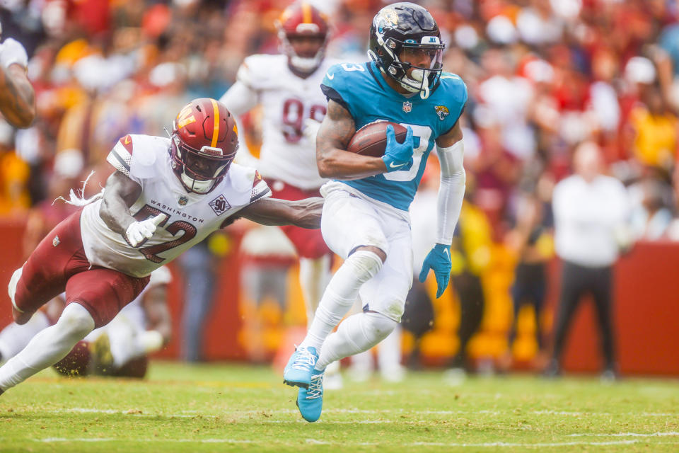 Jacksonville Jaguars wide receiver Christian Kirk (13) carries the ball as Washington Commanders linebacker Jamin Davis (52) tries to stop him during the second half of a NFL football game between the Washington Commanders and the Jacksonville Jaguars on Sunday, Sept. 11, 2022 at FedExField in Landover, Md. (Shaban Athuman/Richmond Times-Dispatch via AP)