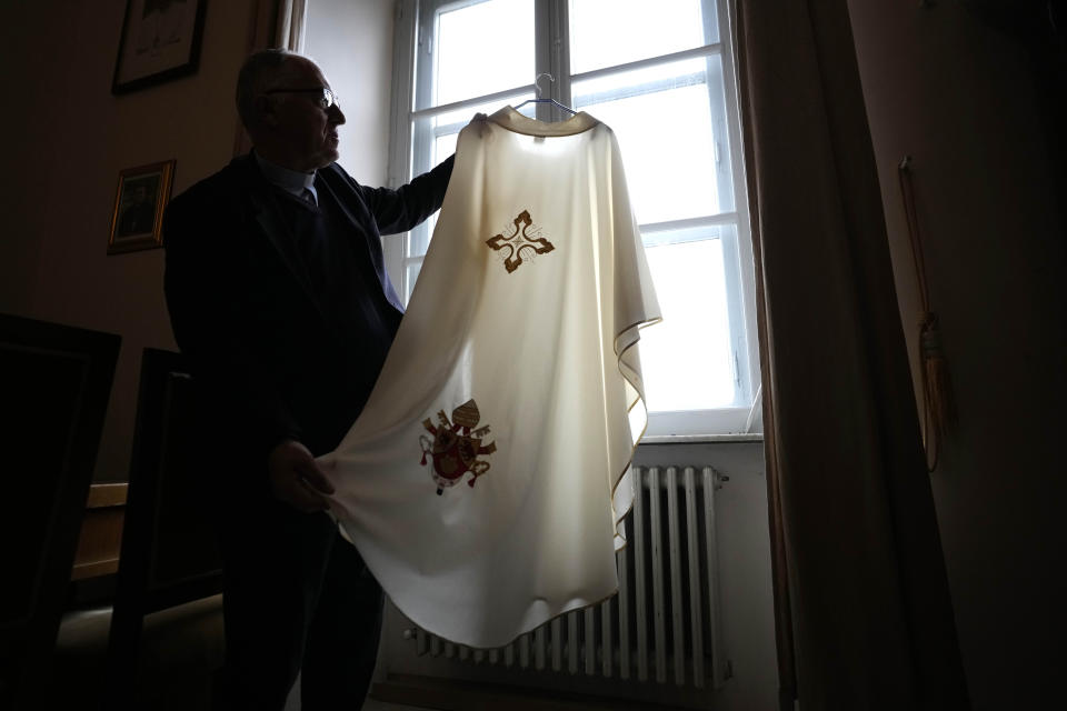 Father Tadeusz Rozmus shows a cassock belonging to the late Pope Emeritus Benedict XVI during an interview with the Associated Press in the San Tommaso Da Villanova Parrish church in Castel Gandolfo, in the hills south of Rome, Tuesday Jan. 3, 2023. Benedict's death has hit Castel Gandolfo's "castellani" particularly hard, since many knew him personally, and in some ways had already bid him an emotional farewell on Feb. 28, 2013, when he uttered his final words as pope from the palace balcony overlooking the town square. (AP Photo/Alessandra Tarantino)