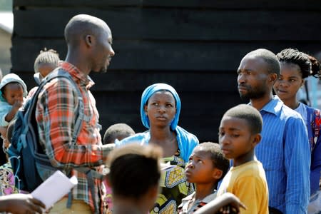 A health worker speaks to people who are waiting to receive the Ebola vaccination in Goma