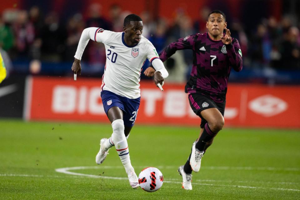 The USMNT's Tim Weah (20) dribbles the ball while Mexico's Luis Romo defends during the World Cup qualifier at TQL Stadium in Cincinnati.
