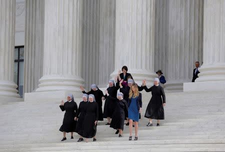 Nuns with Little Sisters of the Poor wave after Zubik v. Burwell, an appeal brought by Christian groups demanding full exemption from the requirement to provide insurance covering contraception under the Affordable Care Act, was heard by the U.S. Supreme Court. REUTERS/Joshua Roberts