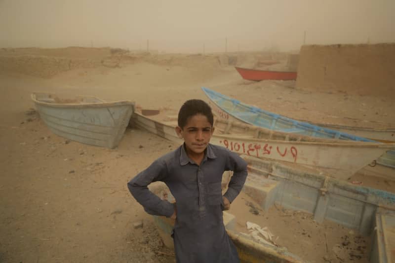 A boy stands in front of old and abandoned boats where there was once a lake. The Iranian province of Sistan and Balochistan is affected by drought and water shortages. Scorching heat, drought and sandstorms plague the inhabitants of the border region between Afghanistan and Iran. At times, water is so scarce in the provinces that it is brought to the villages by tanker. Mohammad Dehdast/dpa