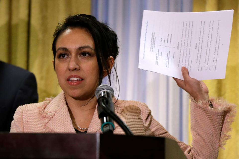 Gloria Schmidt, attorney for Olabinjo Osundairo and Abimbola Osundairo, holds up a copy of their defamation suit against Mark Geragos and lawyers from his firm who represented Jussie Smollett.