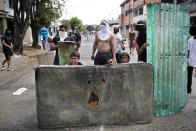 Opositores usan un colchón y un pedazo de aluminio para ocultarse, durante un enfrentamiento con la policía en la protesta contra el gobierno de Nicolás Maduro, en Valencia Venezuela, el miércoles 26 de febrero de 2014. Las protestas iniciaron con estudiantes en distintas ciudades, quienes están molestos por el crimen, los problemas económicos y la mano dura con la que la policía les ha respondido. (AP Photo/Rodrigo Abd)