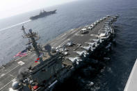 CORRECTS DATE - In this Friday, May 17, 2019, photo released by the U.S. Navy, the USS Abraham Lincoln sails in the Arabian Sea near the amphibious assault ship USS Kearsarge. Commercial airliners flying over the Persian Gulf risk being targeted by "miscalculation or misidentification" from the Iranian military amid heightened tensions between the Islamic Republic and the U.S., American diplomats warned Saturday, May 18, 2019, even as both Washington and Tehran say they don't seek war. (Mass Communication Specialist 1st Class Brian M. Wilbur, U.S. Navy via AP)