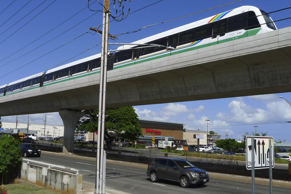 FILE - In this May 30, 2017, file photo, a rail car tops an elevated rail line in Waipahu, Hawaii. Honolulu is building one of the nation's most expensive rail lines to address some of the nation's worst traffic but tax revenue declines during the pandemic and spiraling costs mean it doesn't currently have enough money to finish the 20-mile route as planned. (AP Photo/Cathy Bussewitz, File)