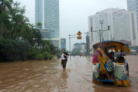 People wade through floodwaters in Jakarta's central business district on January 17, 2013 in Jakarta, Indonesia. Thousands of Indonesians were displaced and the capital was covered in many key areas in over a meter of water after days of heavy rain. (Photo by Ed Wray/Getty Images)