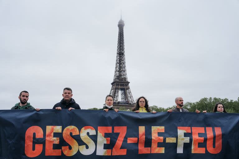Manifestantes llaman a un alto el fuego en una marcha en las inmediaciones de la Torre Eiffel de París  