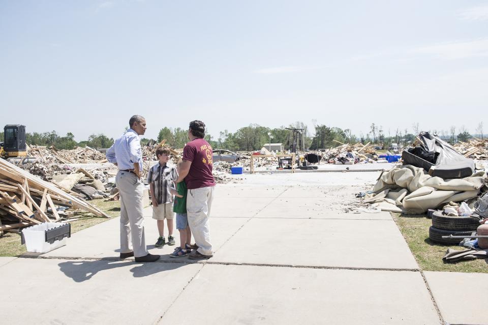 President Barack Obama speaks with resident Daniel Smith during a tour of tornado-damaged areas May 7, 2014 in Vilonia, Arkansas. Obama was surveying rebuilding efforts after tornados in the region.