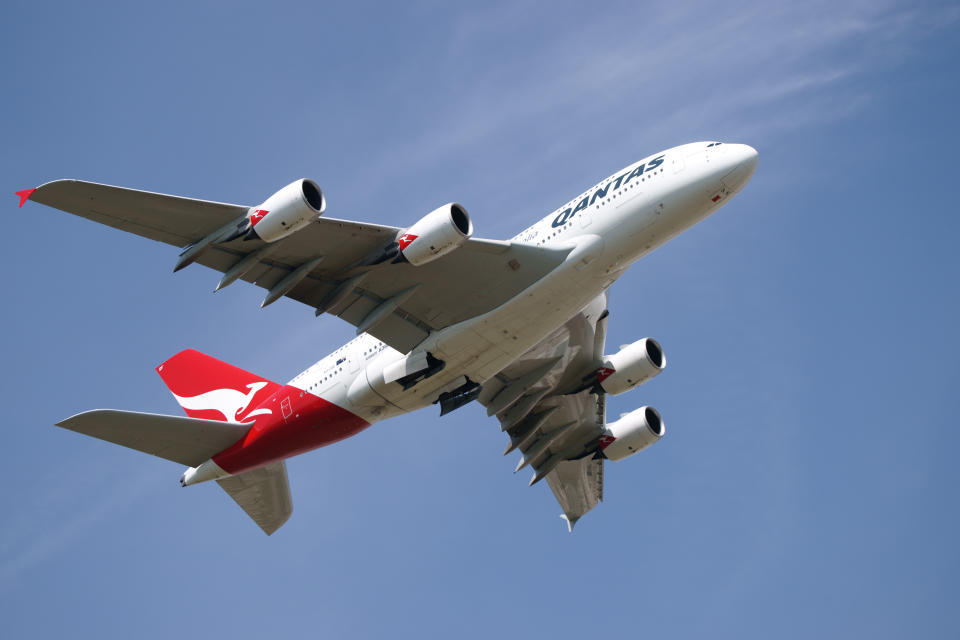 A view from underneath a Qantas aeroplane taking off.
