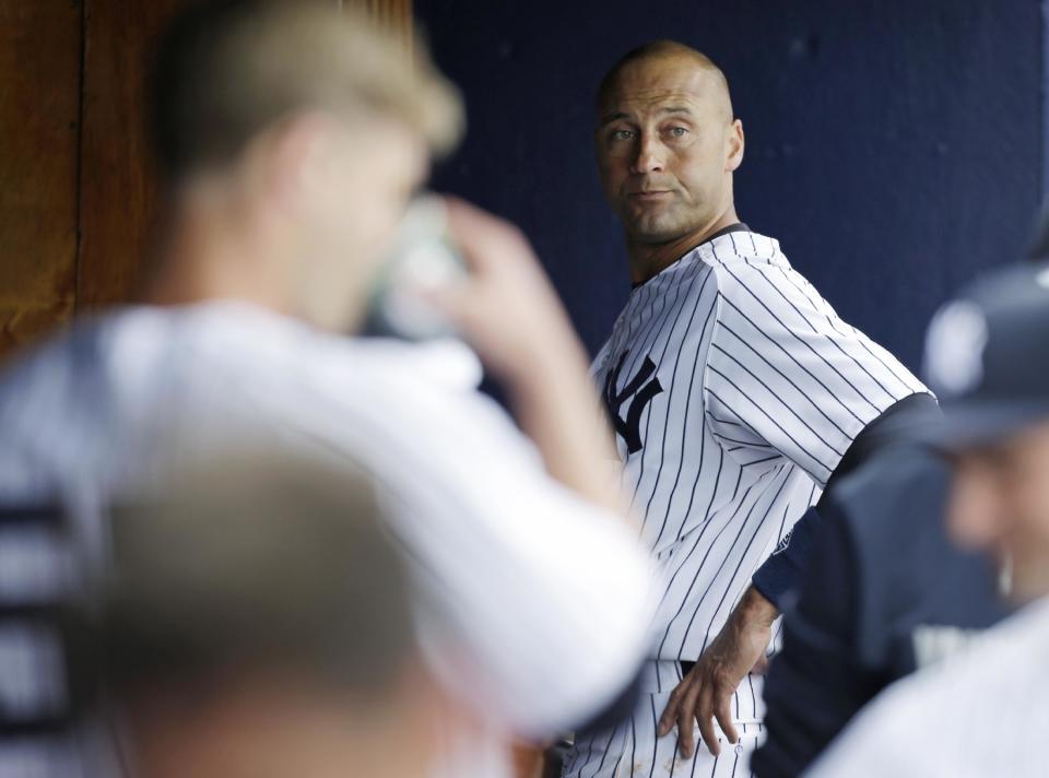 New York Yankees shortstop Derek Jeter, right, stands in the dugout during an exhibition baseball game against the Pittsburgh Pirates Thursday, Feb. 27, 2014, in Tampa, Fla. (AP Photo/Charlie Neibergall)