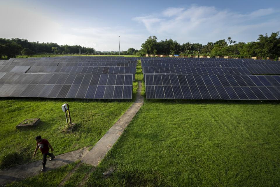 An employee walks away from solar panels near a hydrogen plant at Oil India Limited in Jorhat, India, Thursday, Aug. 17, 2023. Green hydrogen is being touted around the world as a clean energy solution to take the carbon out of high-emitting sectors like transport and industrial manufacturing. But it's not green hydrogen unless the energy used to produce it is renewable, like solar or wind energy. (AP Photo/Anupam Nath)