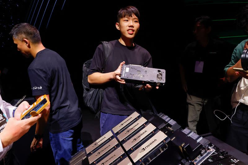 A man holds a processor signed by Nvidia Corp CEO Jensen Huang after his speech at the COMPUTEX forum in Taipei