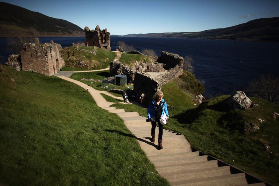 SCOTLAND: Tourists visit Urquhart Castle on Loch Ness in Drumnadrochit, Scotland, United Kingdom.