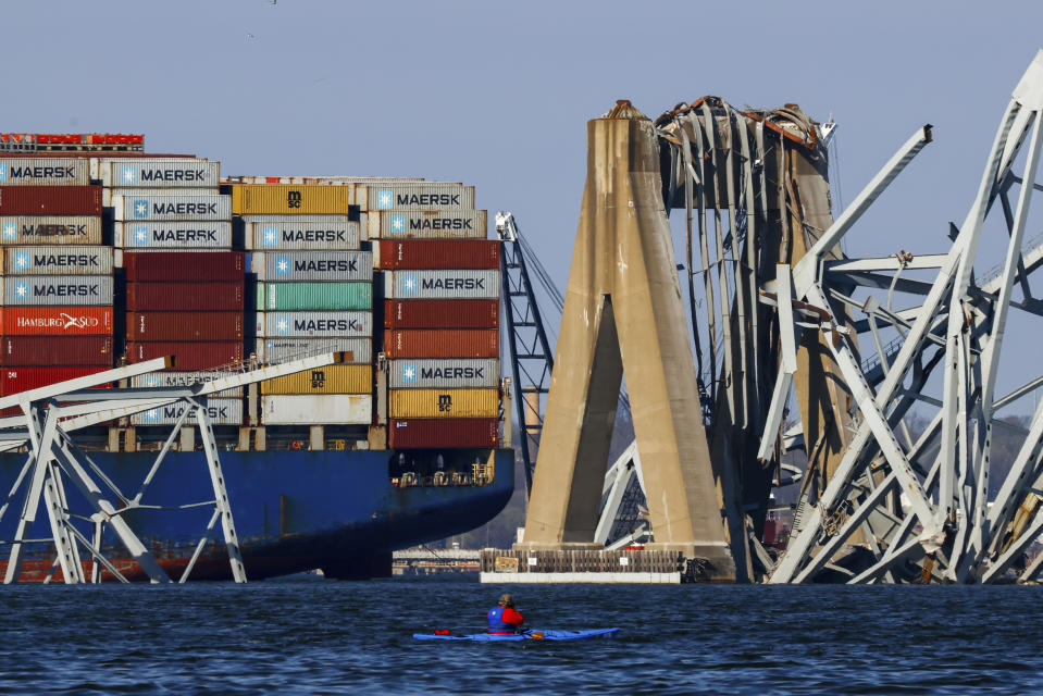 Cranes stand by as the wreckage of the Francis Scott Key Bridge rests on the container ship Dali, Saturday, March 30, 2024, in Baltimore. (AP Photo/Julia Nikhinson)