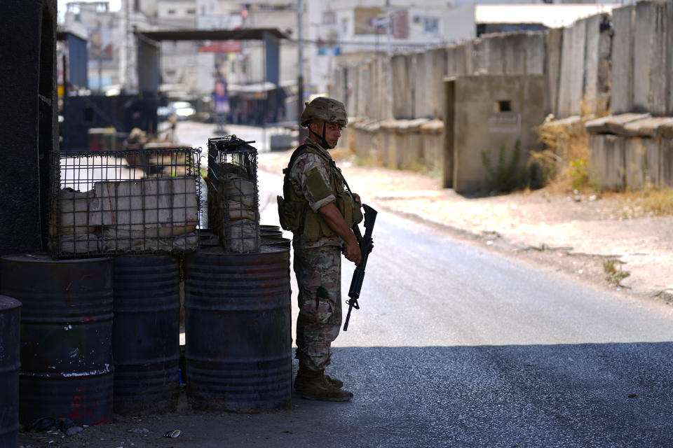 A Lebanese army soldier stands guards at the entrance of Palestinian refugee camp of Ein el-Hilweh during clashes between members of the Palestinian Fatah group and Islamist militants near the southern port city of Sidon, Lebanon, Sunday, Sept. 10, 2023. Islamist factions in Lebanon's largest Palestinian refugee camp said Sunday they will abide by a cease-fire after three days of clashes killed at least five people and left hundreds of families displaced. (AP Photo/Bilal Hussein)