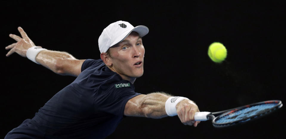 United States' Mitchell Krueger reaches for a backhand return to Serbia's Novak Djokovic during their first round match at the Australian Open tennis championships in Melbourne, Australia, Tuesday, Jan. 15, 2019. (AP Photo/Kin Cheung)