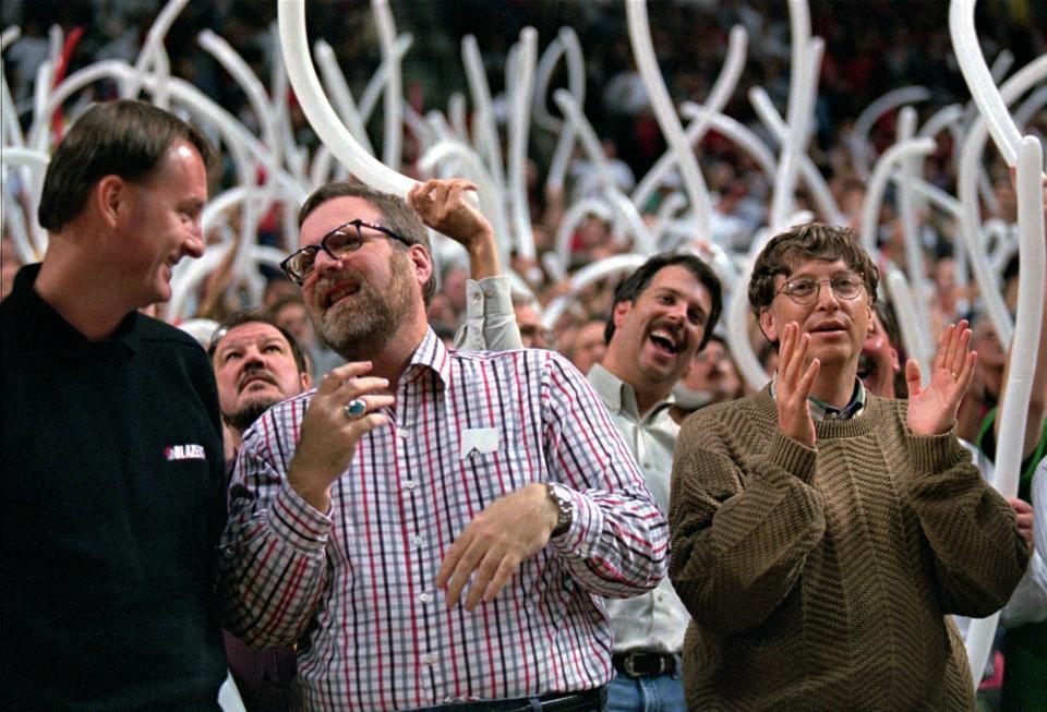 FILE - In this April 30, 1997, file photo, Portland Trail Blazers owner Paul Allen, middle, is joined by Blazers President Bob Whitsitt, left, Microsoft chairman and founder Bill Gates, right and fans as they celebrate the Blazers 98-90 win over the Los Angeles Lakers in game three of first-round NBA playoff action in Portland, Ore. Allen, billionaire owner of the Portland Trail Blazers and the Seattle Seahawks and Microsoft co-founder, died Monday, Oct. 15, 2018 at age 65. Earlier this month Allen said the cancer he was treated for in 2009, non-Hodgkin's lymphoma, had returned. (AP Photo/Jack Smith, File)