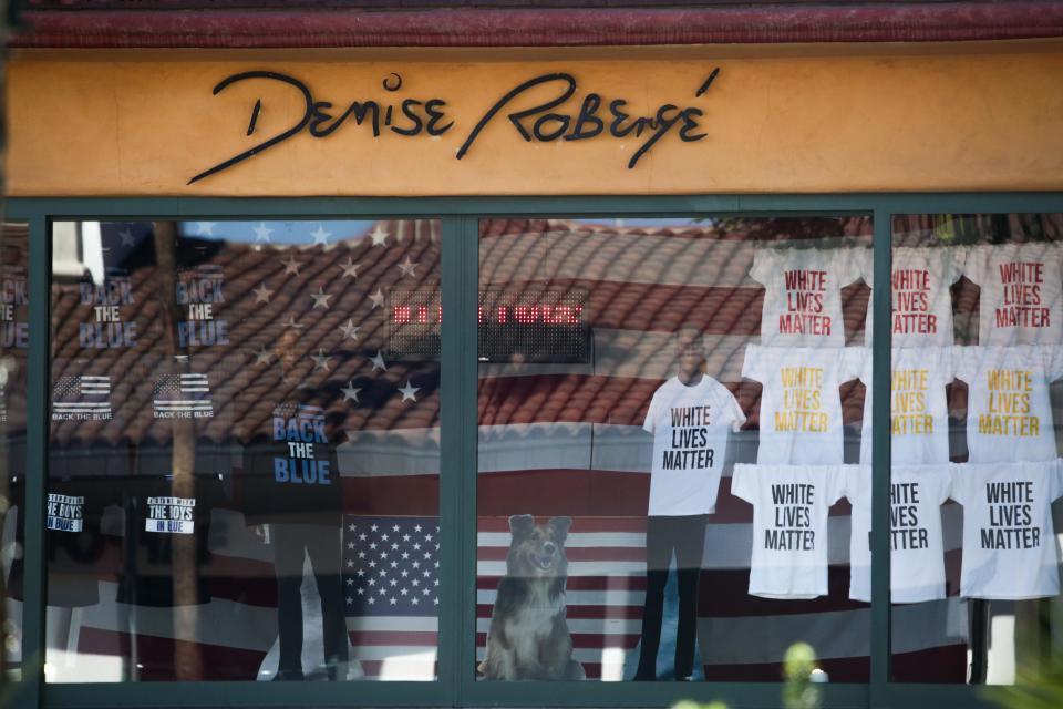 A window display shows shirts reading "white lives matter" and "back the blue" at Denise Robergé Jewelry and Art Gallery on El Paseo Drive in Palm Desert, Calif. on Monday, October 13, 2020.